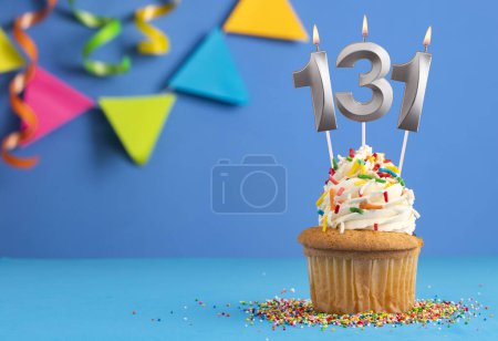 Téléchargez les photos : Bougie numéro 131 - Cupcake anniversaire en arrière-plan bleu - en image libre de droit