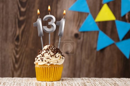 Téléchargez les photos : Carte d'anniversaire avec bougie numéro 131 - Fond en bois avec des fanions - en image libre de droit