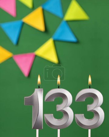 Foto de Tarjeta de cumpleaños vertical con número 133 vela Fondo verde con banderines - Imagen libre de derechos