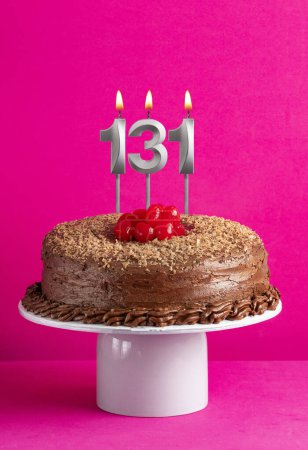 Téléchargez les photos : Carte d'anniversaire avec bougie numéro 131 - Gâteau au chocolat sur fond rose - en image libre de droit