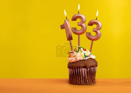 Foto de Vela con número de llama 133 - Tarjeta de cumpleaños sobre fondo amarillo - Imagen libre de derechos