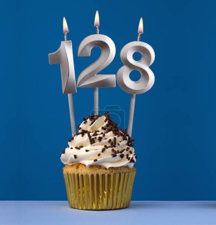 Foto de Tarjeta de cumpleaños vertical con cupcake - Encender la vela número 128 sobre fondo azul - Imagen libre de derechos