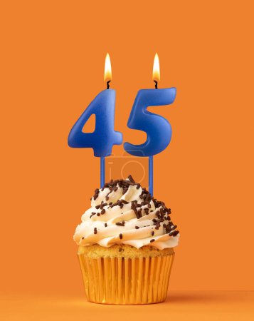 Foto de Vela azul número 45 - Pastel de cumpleaños sobre fondo naranja - Imagen libre de derechos