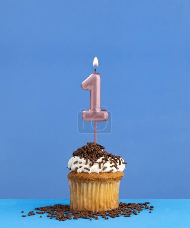 Téléchargez les photos : Bougie d'anniversaire avec cupcake sur fond bleu - Numéro 1 - en image libre de droit