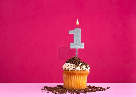 Téléchargez les photos : Cupcake d'anniversaire avec bougie numéro 1 - Carte d'anniversaire sur fond rose - en image libre de droit