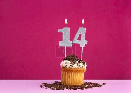Célébration d'anniversaire avec bougie numéro 14 - cupcake au chocolat sur fond rose