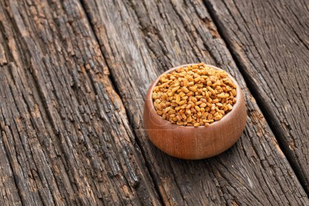 Methi Dana - Dried organic fenugreek seeds in the wooden bowl