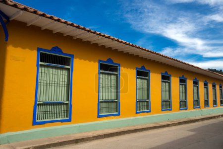 Foto de San Roque, Antioquia - Colombia - 11 de septiembre de 2022. Arquitectura tradicional colombiana, fachada blanca con puertas y ventanas verdes. - Imagen libre de derechos