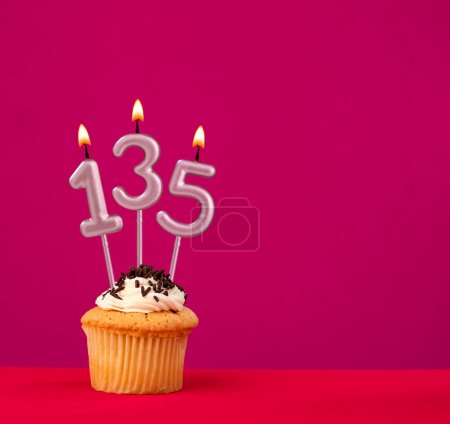 Geburtstagstorte mit Kerze Nummer 135 - Rhodaminrot schaumigen Hintergrund