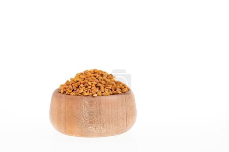 Dried organic fenugreek seeds in the wooden bowl - Trigonella foenum - graecum