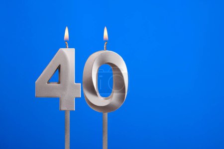 Geburtstag Nummer 40 - Kerze auf blauem Hintergrund angezündet