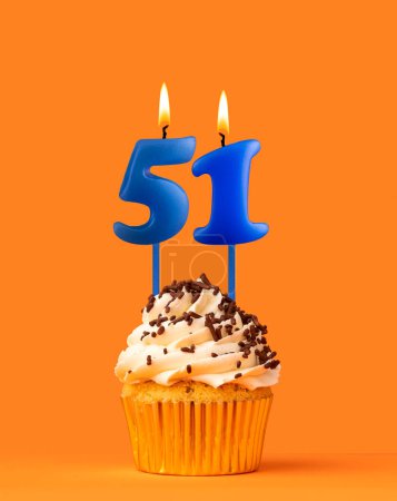 Foto de Vela azul número 51 - Pastel de cumpleaños sobre fondo naranja - Imagen libre de derechos