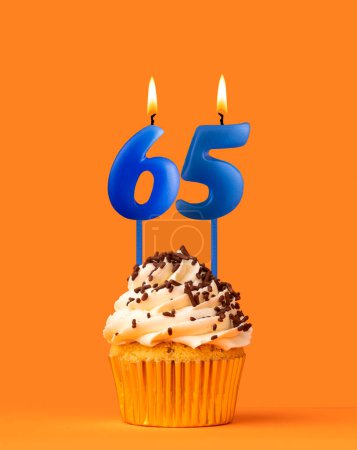 Vela azul número 65 - Pastel de cumpleaños sobre fondo naranja