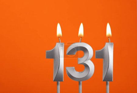 Téléchargez les photos : 131 bougie - Fête d'anniversaire sur fond orange - en image libre de droit