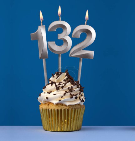 Photo for Vertical birthday card with cupcake - Lit candle number 132 on blue background - Royalty Free Image