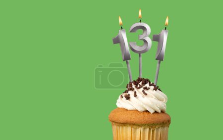 Téléchargez les photos : Anniversaire avec numéro 131 bougie et cupcake - Carte d'anniversaire sur fond de couleur verte - en image libre de droit
