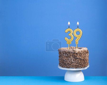 Geburtstagsfeier mit Kerze 39 - Schokoladenkuchen auf blauem Hintergrund