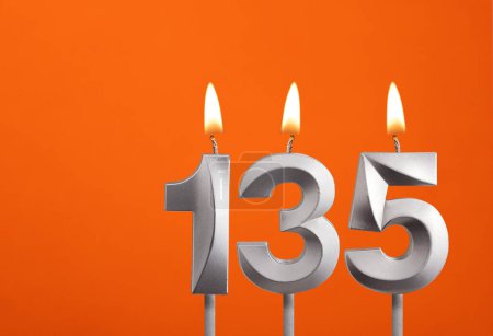 135 Kerze - Geburtstagsfeier auf orangefarbenem Hintergrund