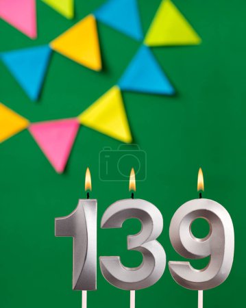 Vertical birthday card with number 139 candle - Green background with pennants