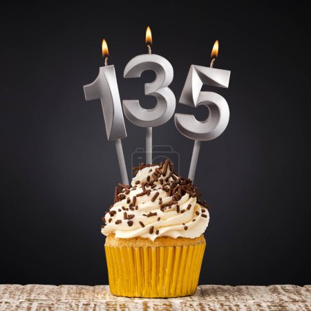 Geburtstagskerze Nummer 135 - Jubiläums-Cupcake auf schwarzem Hintergrund