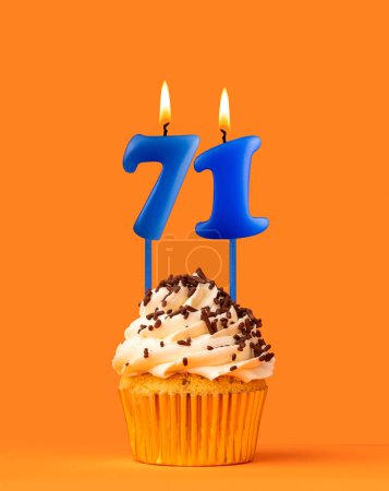 Blaue Kerze Nummer 71 - Geburtstagskuchen auf orangefarbenem Hintergrund