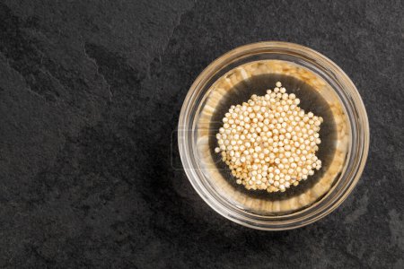 Téléchargez les photos : Chenopodium quinoa - graines de quinoa fermentées avec de l'eau dans un bol en verre - en image libre de droit