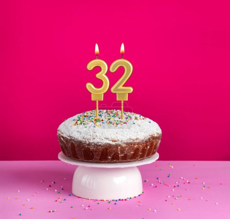 Lighted birthday candle number 32 - Birthday card on pink background