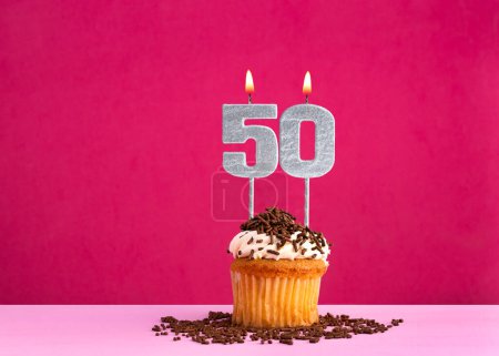 Célébration d'anniversaire avec bougie numéro 50 - cupcake au chocolat sur fond rose