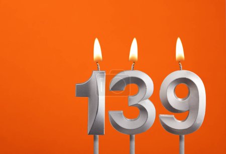 139 candle - Birthday celebration on orange background