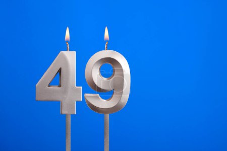 Birthday candle number 49 - Celebration card on blue background