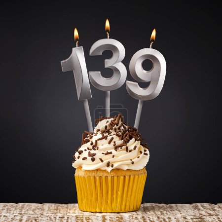 Birthday candle number 139 - Anniversary cupcake on black background