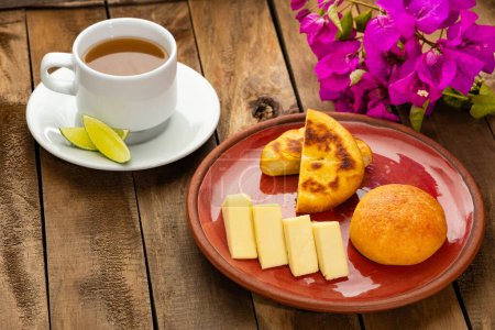 Téléchargez les photos : Petit déjeuner servi à table - Arepa, almojabana, fromage et aguapanela chaud. Gastronomie colombienne - en image libre de droit