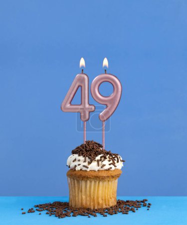 Birthday candle with cupcake on blue background - Number 49
