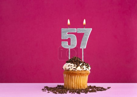 cupcake d'anniversaire avec bougie numéro 57 - Carte d'anniversaire sur fond rose