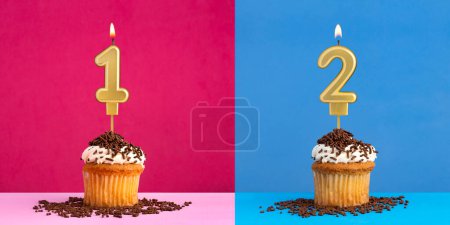 Téléchargez les photos : Deux cupcakes d'anniversaire avec les numéros 1 et 2 - fond bleu et rose - en image libre de droit