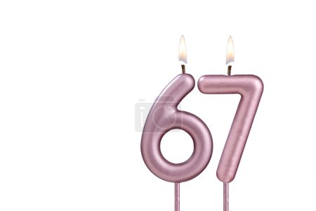 Candle number 67 - Lit birthday candle on white background