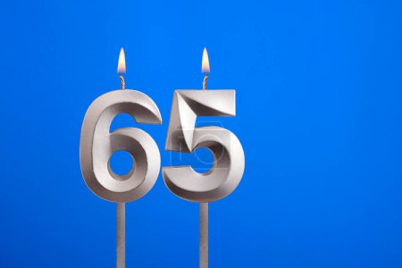 Birthday candle number 65 - Celebration card on blue background