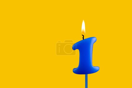 Téléchargez les photos : Bougie d'anniversaire bleue sur fond jaune - Numéro 1 - en image libre de droit