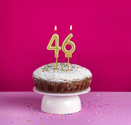 Lighted birthday candle number 46 - Birthday card on pink background