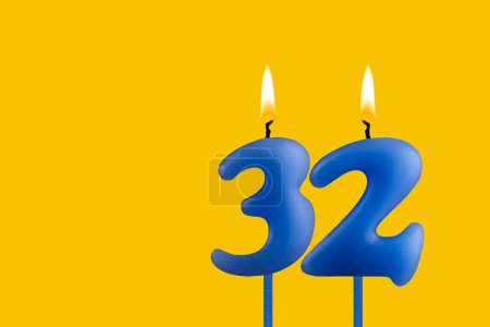Blue candle number 32 - Birthday on yellow background