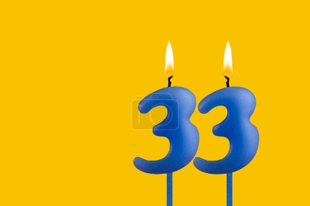 Blaue Geburtstagskerze auf gelbem Hintergrund - Nummer 33