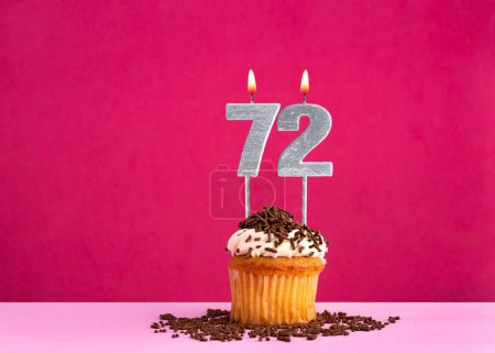 Celebración de cumpleaños con número de vela 72 - Pastel de chocolate sobre fondo rosa