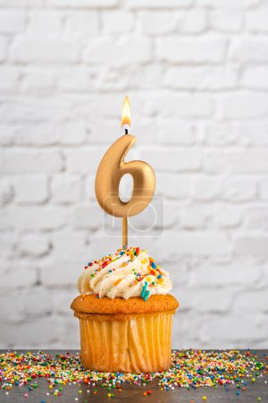Cupcake with number 6 birthday candle - White block wall background