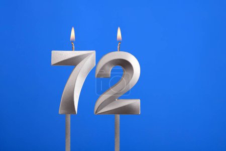 Birthday number 72 - Candle lit on blue background