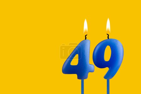 Blue birthday candle on yellow background - Number 49