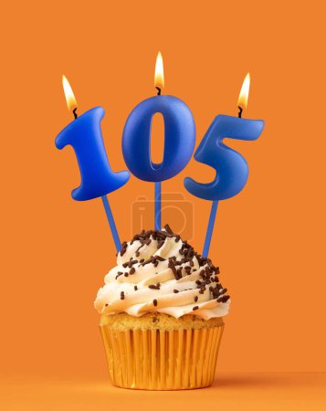 Blaue Kerze Nummer 105 - Geburtstagskuchen auf orangefarbenem Hintergrund