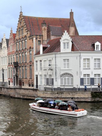 Foto de Sightseeing boat trip in canal on a rainy day in Bruges, Belgium - Imagen libre de derechos