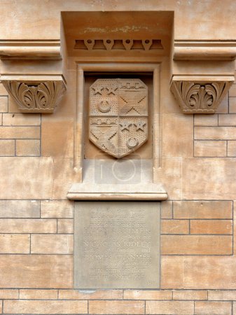 Foto de Cresta heráldica en la pared del Balliol College en Broad Street e inscripción dedicada a los mártires de Oxford, obispos protestantes quemados en la hoguera en el siglo XVI en Oxford. - Imagen libre de derechos