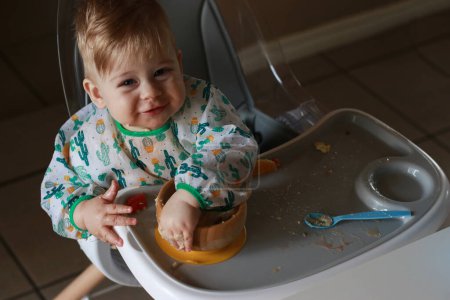Téléchargez les photos : Baby eating by himself learning through the Baby-led Weaning method, exploring the food - en image libre de droit