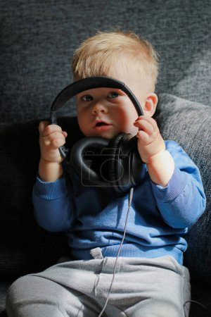 Foto de Niño jugando con auriculares en el sofá. Foto de alta calidad - Imagen libre de derechos